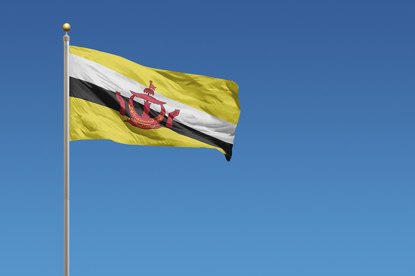 Flag of in front of a clear blue sky